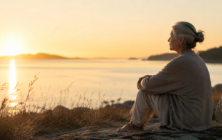 A mature person sitting quietly in soft morning light, symbolising silence, self-awareness and returning to the true self.